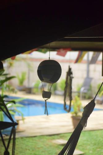 a light hanging from a tent with a pool in the background at Hostel Trópico de Capricórnio - Tenório in Ubatuba