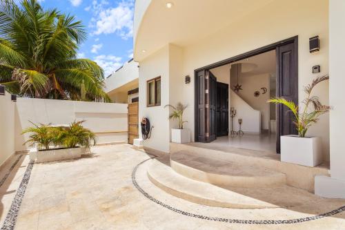 a house with a courtyard with palm trees at Casa Javi- Ocean Front located Mid Isla Mujeres in Isla Mujeres