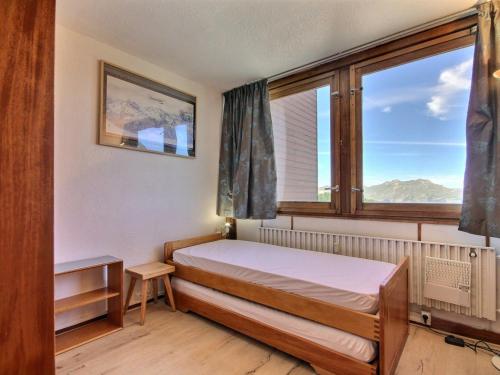 une chambre avec un lit et une grande fenêtre dans l'établissement Appartement 2 pièces au pied des pistes, balcon, cuisine équipée - FR-1-455-259, à La Plagne Tarentaise