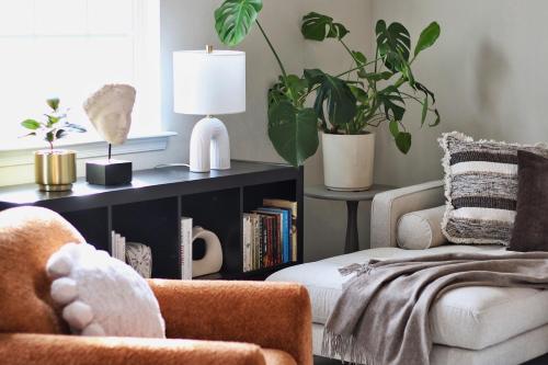 a living room with two chairs and a book shelf with plants at RiverWinds - Modern Charm Near Shenandoah National Park in Luray
