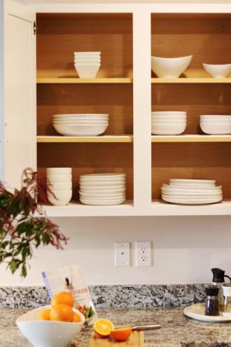 a kitchen cabinet with plates and bowls in it at RiverWinds - Modern Charm Near Shenandoah National Park in Luray