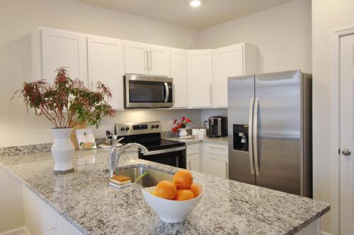 a kitchen with a sink and a bowl of oranges on a counter at RiverWinds - Modern Charm Near Shenandoah National Park in Luray