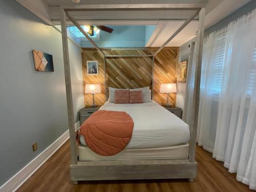 a bedroom with a canopy bed with two lamps at Peace & Plenty Inn Bed and Breakfast Downtown St Augustine-Adults Only in Saint Augustine