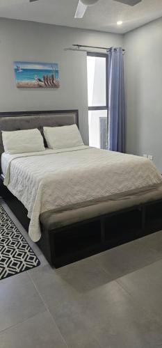 a large bed in a bedroom with a window at Royale Escape in Cardiff Hall