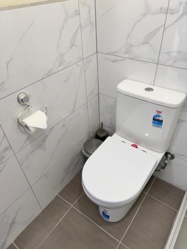 aseo blanco en un baño con paredes de mármol en Prime location bedroom, en Albion