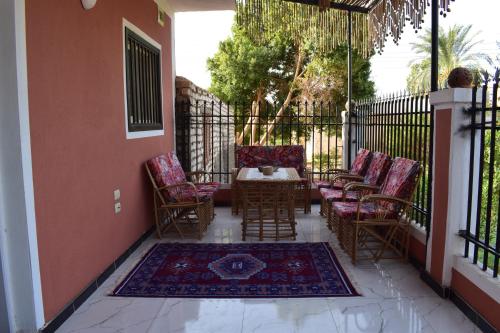 a patio with chairs and a table on a balcony at Karma Kono in Abu Simbel