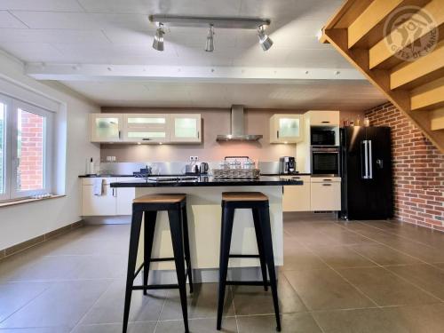 a kitchen with a counter and two stools in it at Maison avec grand jardin clos, baby-foot, barbecue, garage, Wi-Fi - Calme et confort en Flandre - FR-1-510-221 in Eecke