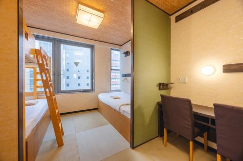 a small room with a bunk bed and a desk at COGO Ryogoku in Tokyo