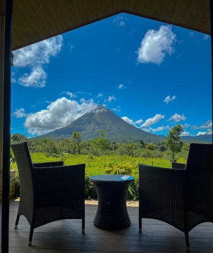 a view of a mountain from a table and chairs at Arenal Roca Suites in Fortuna