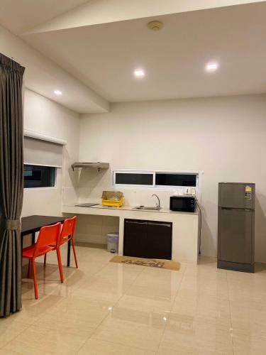 a kitchen with a sink and a table and a refrigerator at Diamond Pool Villa@Samui in Koh Samui 