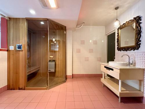a bathroom with a shower and a sink and a mirror at 荷蘭洋行-寵物友善塩水燈會井仔腳塩田 in Xuejia