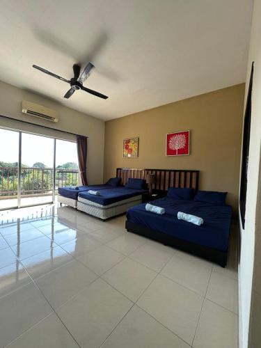 a bedroom with two beds and a ceiling fan at Gold Coast Morib by Tim in Morib
