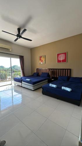 a bedroom with two beds and a ceiling fan at Gold Coast Morib by Tim in Morib