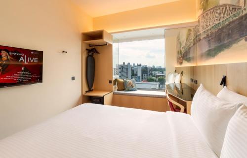 a bedroom with a large white bed and a window at Ibis Singapore on Bencoolen - Newly Renovated in Singapore