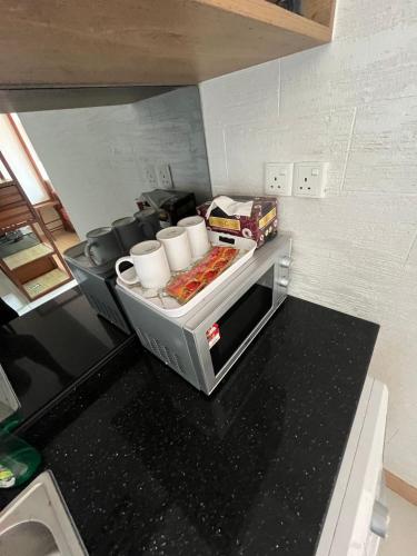 a kitchen with a toaster oven with some food at Salam Suite - TimurBay Seafront Residence in Kampung Sungai Karang