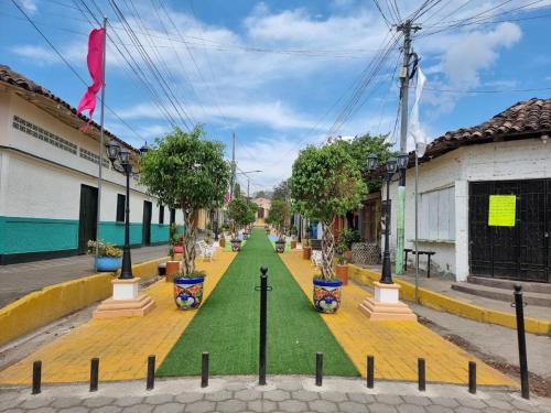 a street in a town with a green lawn at Ometepe House in Moyogalpa