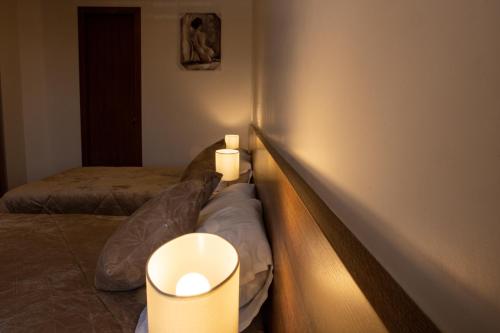 a bedroom with two beds and lights on the wall at Hotel San Benito Cuenca in Cuenca