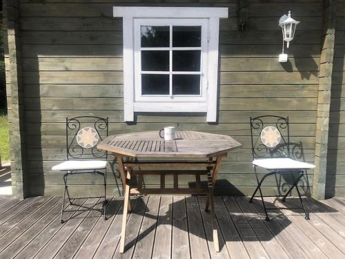 a wooden table and two chairs on a wooden deck at Aasa Summer Cottage in Surepi