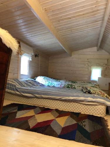 a large bed in a small room with aamed ceilings at Aasa Summer Cottage in Surepi