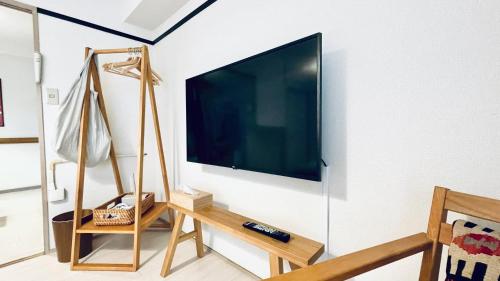 a flat screen tv hanging on a wall at Shinjuku spacious apartment for max 8ppl in Tokyo