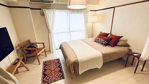 a bedroom with a large bed and a window at Shinjuku spacious apartment for max 8ppl in Tokyo