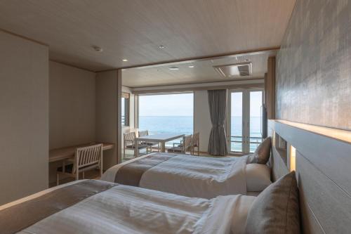 Postel nebo postele na pokoji v ubytování Kamogawa Grand Hotel