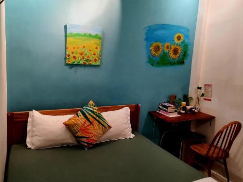 a bedroom with a bed and two paintings on the wall at Sông Suối Homestay in Quy Nhon