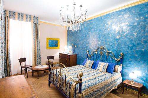 um quarto azul com uma cama e um lustre em B&B Dai Toscans em Cividale del Friuli