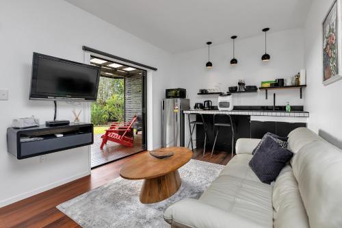 a living room with a couch and a table at Sunrise Lookout - Paihia Holiday Home in Haruru