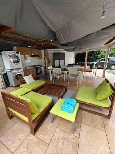 un patio avec des chaises et des tables et une tente dans l'établissement Jolie Villa piscine climatisé 6-8 pers proche centre-ville Perpignan, à Perpignan