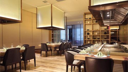 a dining room with tables and chairs and a kitchen at Crowne Plaza Yibin by IHG in Yibin