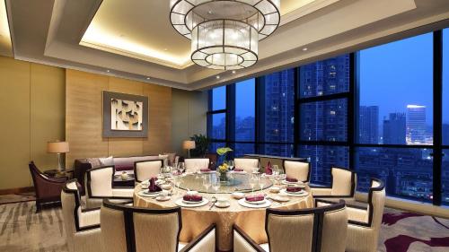 a dining room with a table and chairs and a large window at Crowne Plaza Yibin by IHG in Yibin
