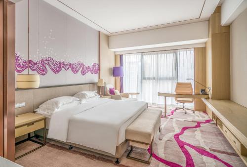 a bedroom with a white bed and a desk at Crowne Plaza Yibin by IHG in Yibin