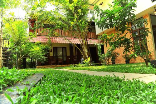 a house with a garden in front of it at Lakefront Beach Homes in Cherai Beach