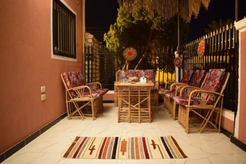a patio with chairs and a table and a fence at Karma Kono in Abu Simbel