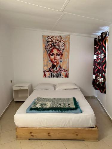 a bed in a room with a painting on the wall at Dolphin Camp in Dahab