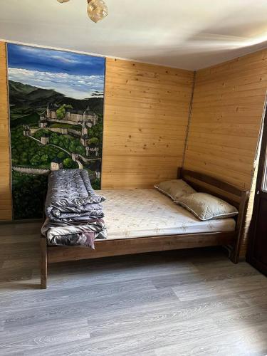 a bed in a room with a painting on the wall at ЛемГора in Vorokhta