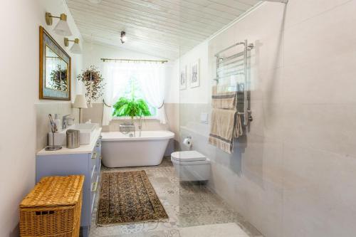 a bathroom with a tub and a toilet and a sink at Pušyno apartamentai in Druskininkai