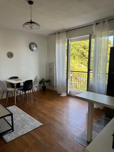 un salon avec une table et une salle à manger avec un balcon dans l'établissement Appartement calme avec vue à 20 minutes de la gare, à Saint-Égrève