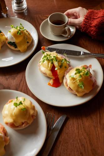 a table with plates of food and a cup of coffee at The White Hart - A Heartwood Inn in Lewes