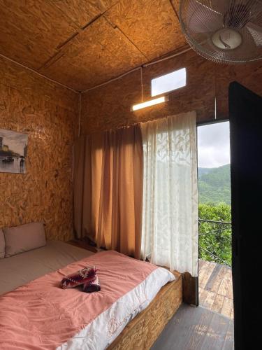 a bed in a room with a large window at HOMESTAY ĐỐM HOUSE in Hoat