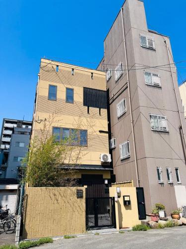 a tall building with a fence in front of it at 桜の舞2号馆 Sakura Dance 2 in Osaka