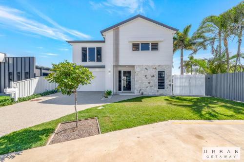 a white house with a fence and a yard at Bargara Coastal Luxe Aircon, Outside Pet, Sleeps 8 in Bargara
