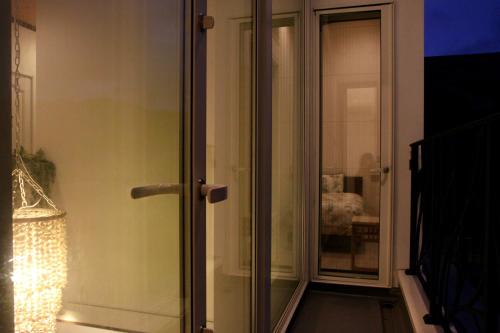 a glass door to a room with a chair at Hale Kotsubo KARAOKE&SPA in Zushi