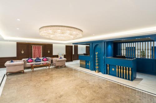 a living room with blue walls and a chandelier at MJ Sarovar Portico Haridwar in Haridwār