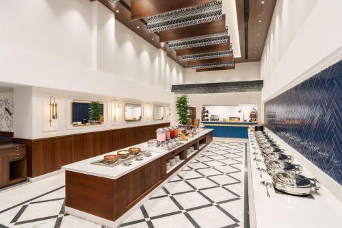 a large kitchen with a long counter in a room at MJ Sarovar Portico Haridwar in Haridwār