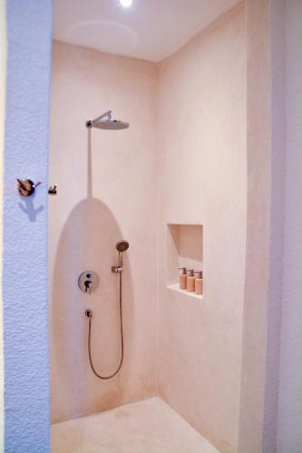 a bathroom with a shower with a shower head at The Balangan Hotel in Jimbaran