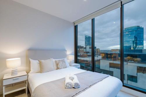 a bedroom with a bed and a large window at Pride Manor South Yarra in Melbourne