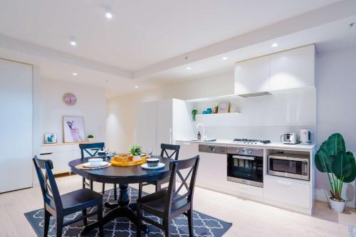 a kitchen and dining room with a table and chairs at Pride Manor South Yarra in Melbourne