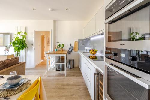a kitchen with white cabinets and a stove top oven at FMSS - City Luxe in London